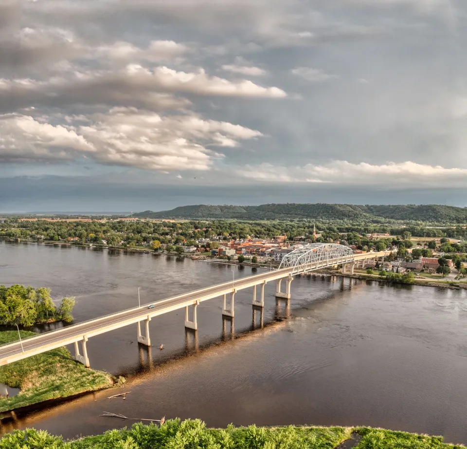 Scenic aerial view of a bridge spanning the Mississippi River in Wabasha, Minnesota under a cloudy sky.