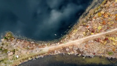 Aerial view of a scenic autumn landscape with vibrant foliage and a serene lake at Cass Lake, Minnesota.